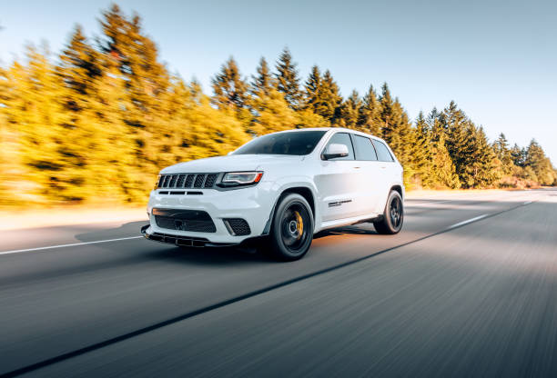 A white lemon Jeep Grand Cherokee driving with engine problems.